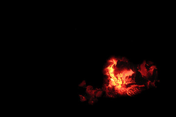 Coals on a black background. Copy space Smoldering embers. The silhouette of Satan. Halloween...