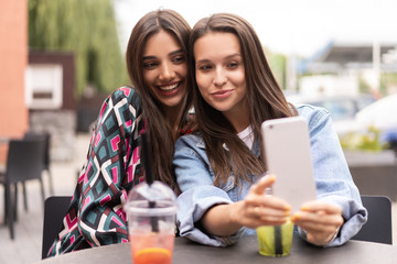 Close up lifestyle selfie portrait of pretty fresh young brunette best friends girls making selfie, having fun