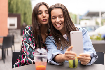 Close up lifestyle selfie portrait of pretty fresh young brunette best friends girls making selfie, having fun