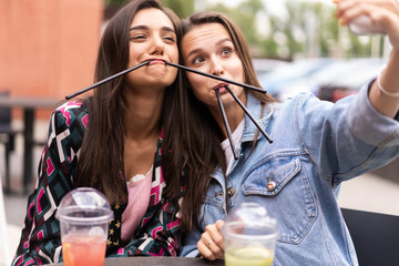 Close up lifestyle selfie portrait of pretty fresh young brunette best friends girls making selfie, having fun