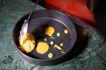 The chef serves the dish Pumpkin Risotto with with duck and parmesan cheese mousse. Seasonal autumnal recipe - risotto with organic pumpkins.