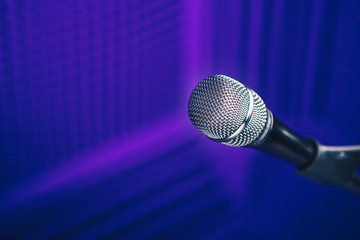 microphone on stand, purple background with acoustic foam wall in studio