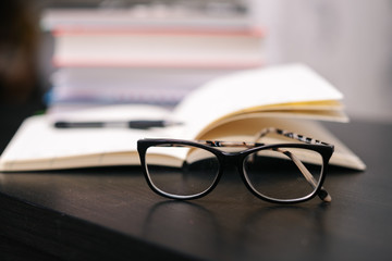 pencil with glasses on a book 