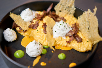 Dinner in restaurant. Pumpkin Risotto with with duck and parmesan cheese mousse. Seasonal autumnal recipe - risotto with organic pumpkins.