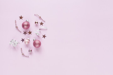 Pink background with christmas decor: balls, stars, festive. Flat lay.
