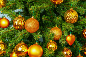 Obraz na płótnie Canvas Christmas tree with golden baubles close up on blue background