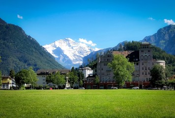 Picture looking through the buildings and can see the mountains with the snow-white peaks covered in Geneva.