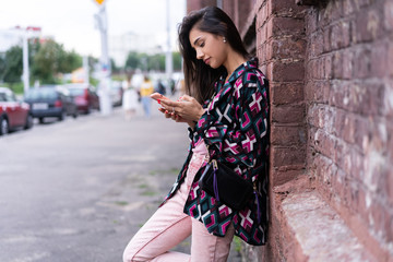 Fototapeta premium Natural young woman reading an sms or text message on a mobile phone
