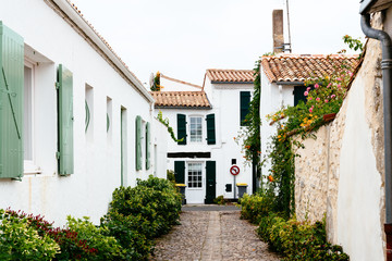 Charming street with traditional old houses and flowers in Saint Martin de Re. Island of Re