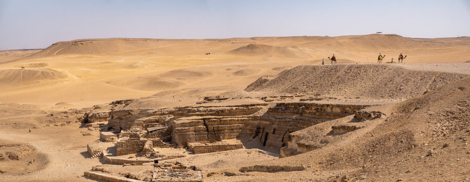 Panoramic view of the Giza Plateau with pharaohs ruins and camel riders, Cairo, Egypt