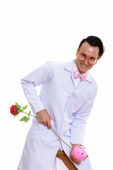 Portrait of crazy young man doctor playing with piggy bank