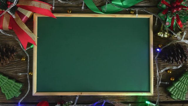 Empty green board placed on wooden table decorated with Christmas decorations.Top view