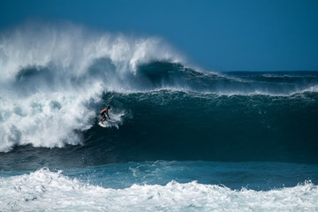 Surfer rides huge wave at the famous Banzai Pipeline surf spot located on the North Shore of Oahu...