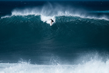 Surfer rides giant wave at the famous Banzai Pipeline surf spot located on the North Shore of Oahu...