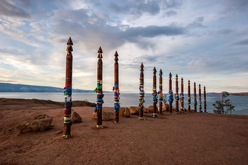 Sacred pillars with tied ribbons on Cape Burhan of Olkhon Island. Buryat traditions. Shamanistic rites of Lake Baikal.