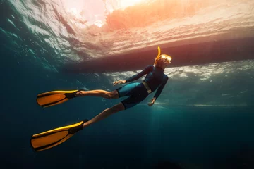 Zelfklevend Fotobehang Woman freediver swims underwater under the boat © Dudarev Mikhail