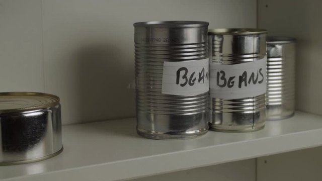 Stocking cupboard with tins of aluminum baked beans