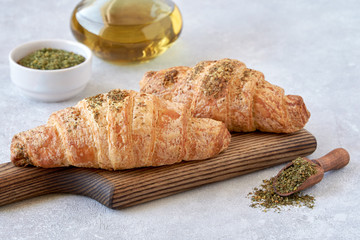 Fresh croissants with zaatar on wooden board	  