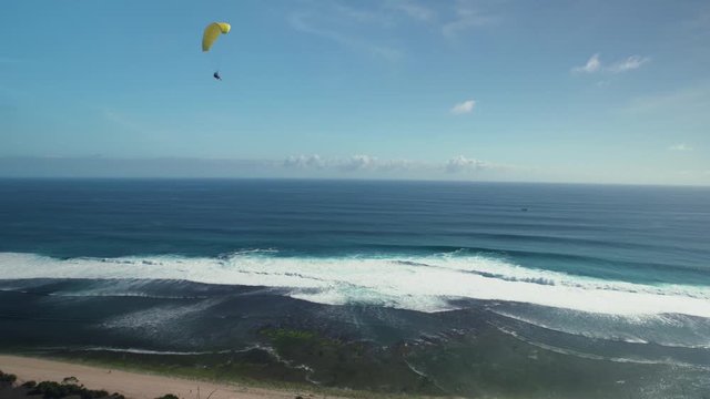 Paraglide fly above ocean coast line in Bali with scenic view 4K video