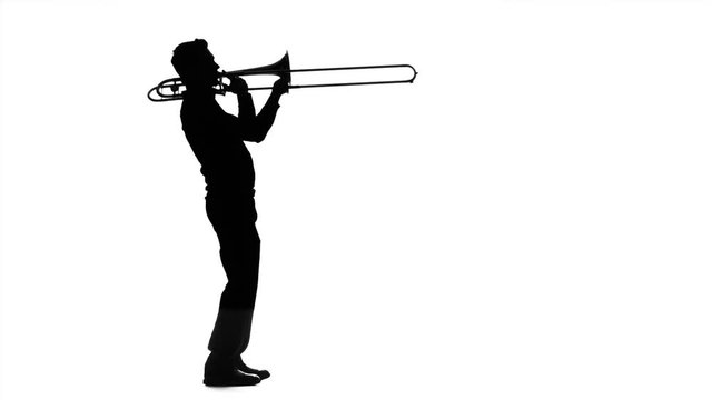 Musician professional playing on trombone in slow motion. Black silhouette