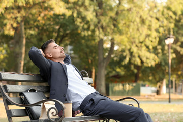 Portrait of handsome businessman relaxing in park
