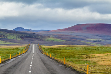 Einsame Straße zwischen farbenprächtigen Hügeln in Island