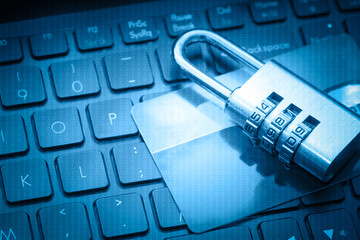Credit card and padlock lying on keyboard symbolizing secure online shopping