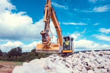 Woman operating an excavator on road works construction site
