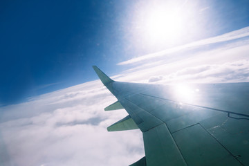 Fototapeta premium Wing of an airplane flying above the clouds