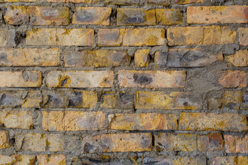 Background of old antique dirty brick wall with peeling plaster, texture
