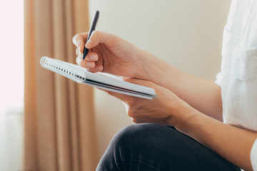 Beautiful female hands hold an open book or magazine in the room