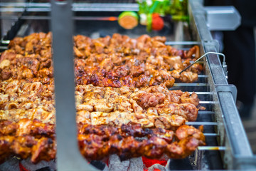Selective focus, chicken kebabs cooking on a charcoal grill at Christmas market winter wonderland in London
