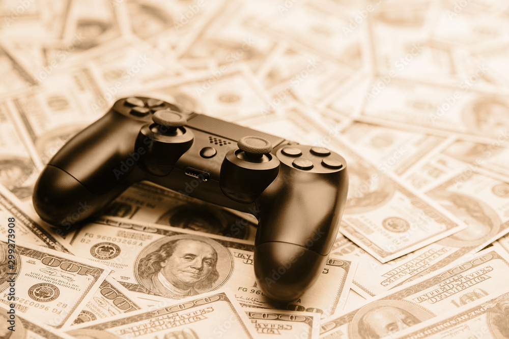 Canvas Prints Concept of gaming addiction. Close up photo of gamepad on the money background.