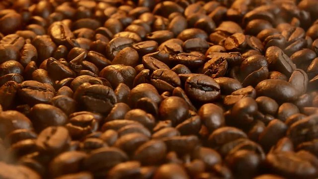 Fragrant fried coffee beans or Fresh roasted coffee beans rotation and rising smoke