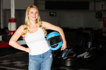Positive female model posing near racing cars
