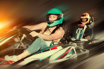 woman driving racing car at kart circuit