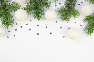 Fototapeta na wymiar Frame mockup Christmas composition. Pine branches and balls with confetti on white background. Flat lay, top view, copy space