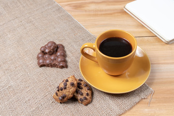 cup of coffee with homemade chocolate sweets cookies on wooden background for notebook planning