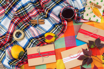 Christmas background with gift boxes, clews of rope, paper's rools and decorations on plaid at home. Preparation for holidays. Top view. Autumn, fall, halloween, thanksgiving day concept