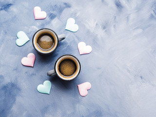 Obraz na płótnie Canvas Two coffee cups, pastel hearts on sky blue. Valentine's day concept background