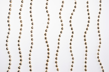 Gold beads isolated on white background. Background made of a brilliant celebratory beads of golden...