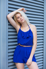 Stylish girl posing near the metal shutters