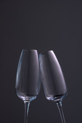 two empty champagne glasses on a dark background