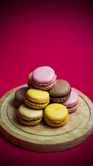 Colored macarons isolated on wooden dish, typical French dish