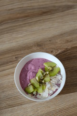 berry smoothie bowl with kiwi and coconut slices