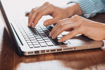 Woman working at home office hand on keyboard close up