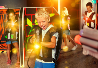 Preteen boy with laser pistol playing on labyrinth