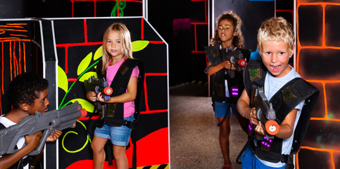 Preteen girls and boys with laser pistols playing laser tag