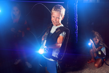Portrait of cheery tweenager boy with laser gun