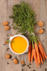 carrot and walnut soup on wood background